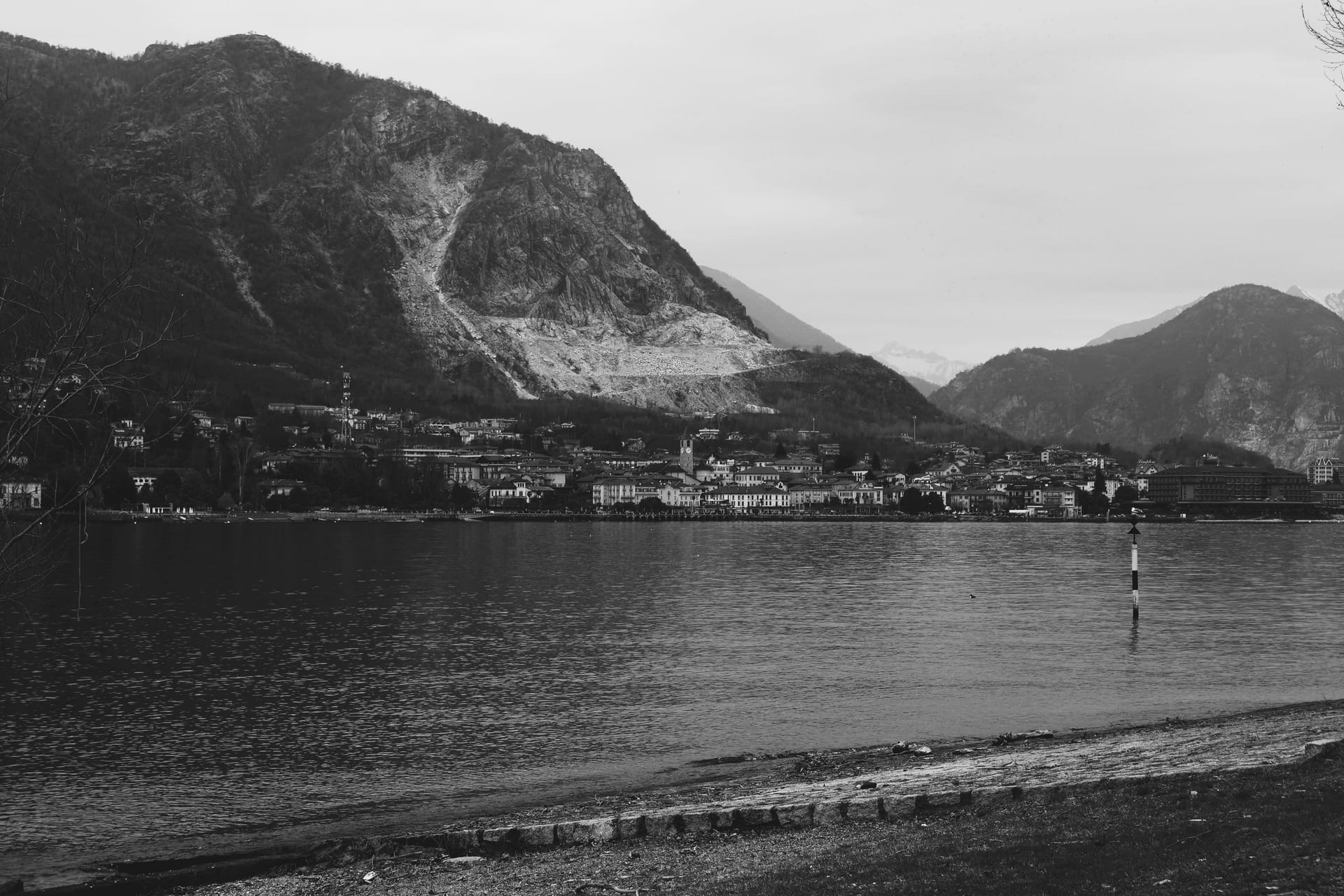 Un borgo del Lago di Como in bianco e nero, con le montagne e una cava sullo sfondo