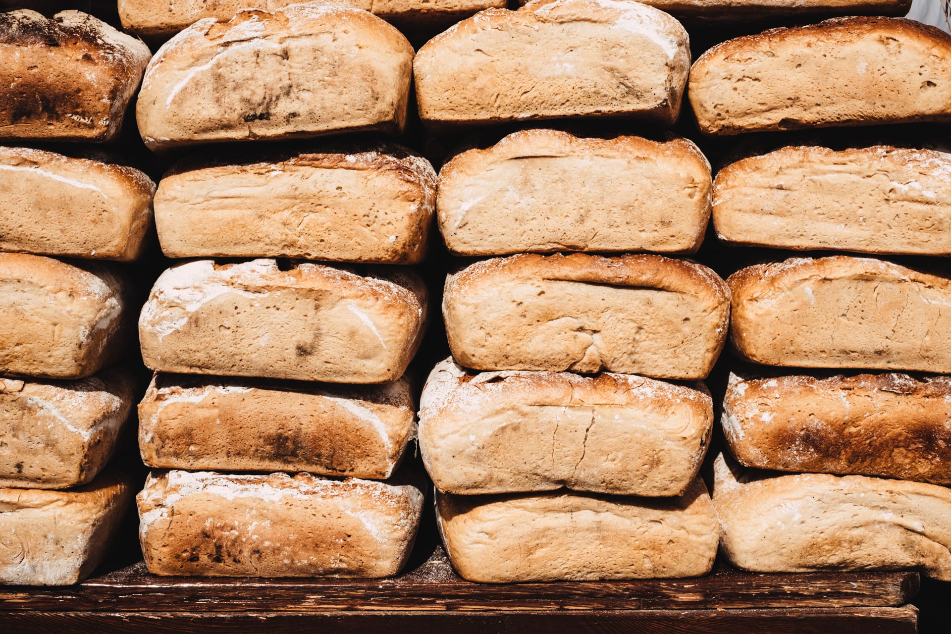 Rustic loaves of bread stacked on a wooden counter